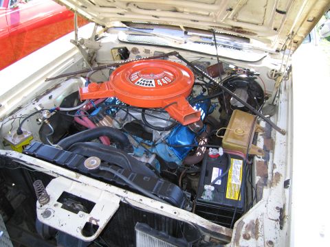 1991 Ford LTD Crown Victoria - The engine bay of a white car, with a prominent orange air cleaner and a partial view of a red car.