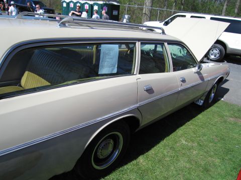 1991 Ford LTD Crown Victoria - Station wagon with roof rack and paper on window, parked on grass next to a white SUV with hood open.