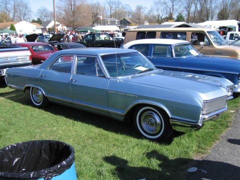 1991 Ford LTD Crown Victoria - A light blue sedan is parked on a grassy field with other vehicles in the background.