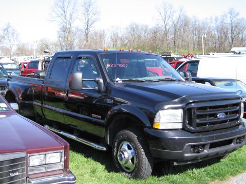 1991 Ford LTD Crown Victoria - A black Ford F-350 Super Duty truck is parked on grass with other vehicles in the background.