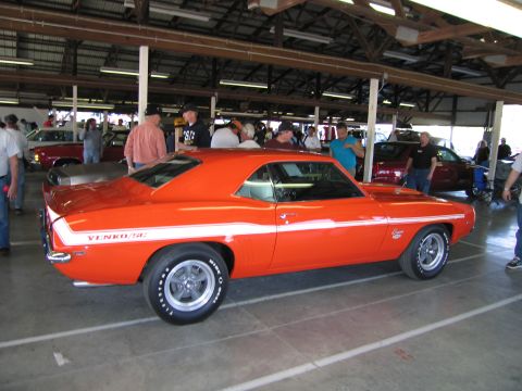 1991 Ford LTD Crown Victoria - Orange 1969 Yenko Camaro with white stripe parked indoors.