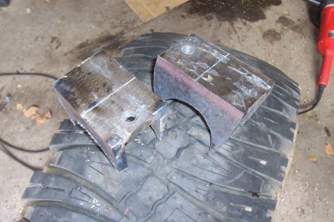 1994 Ford F-150 - Custom metal brackets are placed on a tire, with a grinder nearby.