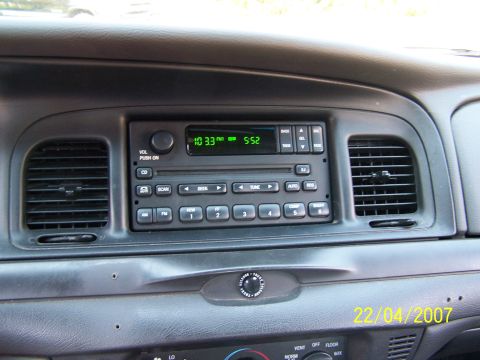 2003 Ford Crown Victoria - The interior of a vehicle is shown, focusing on the dashboard and radio controls.