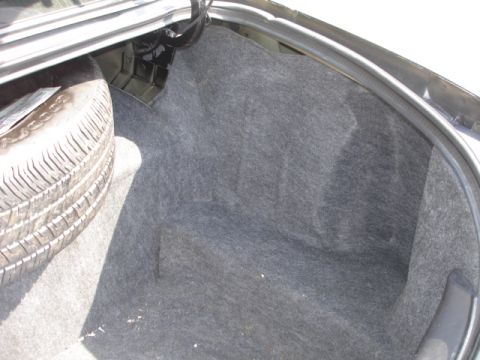 2001 Ford Crown Victoria - The trunk interior of a vehicle, showing the spare tire well and carpeting.