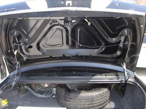 2001 Ford Crown Victoria - The trunk of a car, showing the spare tire and various wiring components.