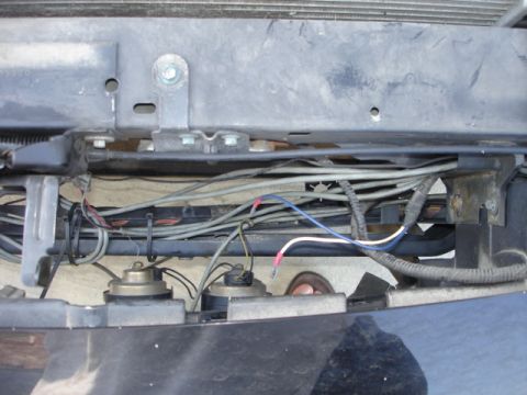 2001 Ford Crown Victoria - Close-up view of car horns and wiring harness located behind the front bumper.