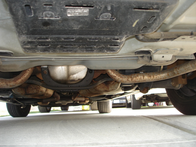 Underside of a 2001 Ford Crown Victoria showing exhaust pipes, differential, and suspension components