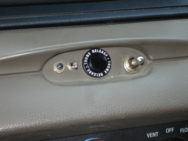 Interior dashboard with trunk release button and toggle switch