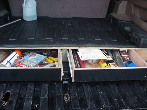 1993 Ford Bronco - View of a truck/SUV cargo bed fitted with a custom two-drawer wooden storage system, the drawers pulled open to reveal tools, tape measures…