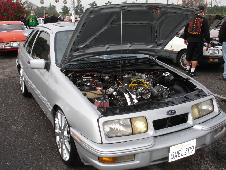 Silver Ford Sierra XR4Ti with hood open, showing engine. Other cars in background