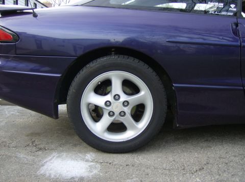 1996 Ford Probe - Close-up of the rear wheel and fender of a purple 1996 Ford Probe.
