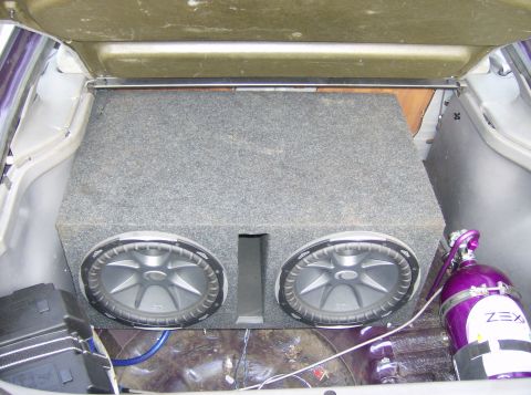 1996 Ford Probe - The trunk of a car is shown with a large subwoofer box and a nitrous oxide tank installed.