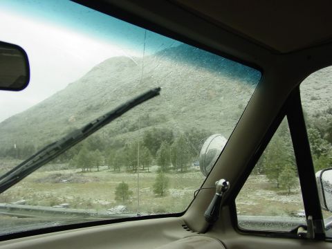1994 Ford Bronco - Driving through a mountainous area with trees and a cloudy sky.