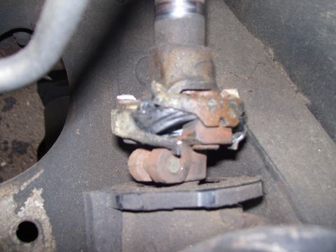 1986 Ford Bronco - This image shows a close-up of a worn suspension component, likely from the underside of a vehicle.