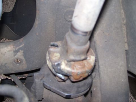 1986 Ford Bronco - Close-up view of a rusty steering linkage component, likely from a vehicle's suspension system.