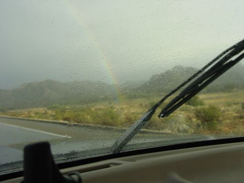 1994 Ford Bronco - Driving through a rainstorm with a rainbow visible through the wet windshield.