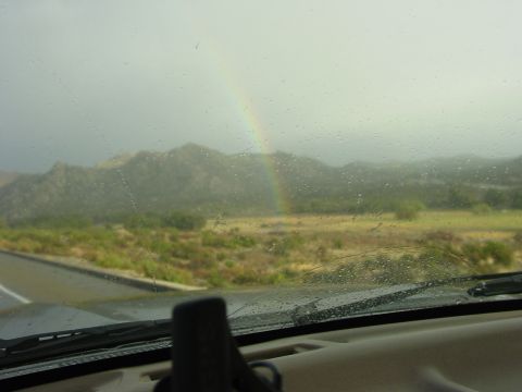1994 Ford Bronco - Rainbow visible through a wet windshield during a drive, with mountains in the background.