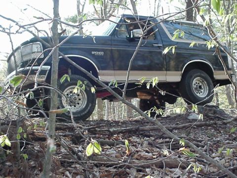 1993 Ford Bronco - This 1993 Ford Bronco is navigating a rough, wooded trail with fallen logs.