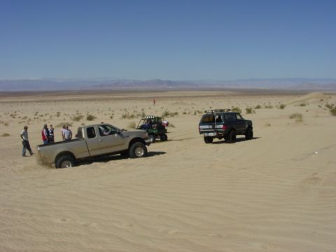 1994 Ford Bronco - Several vehicles are in a desert landscape under a clear blue sky.