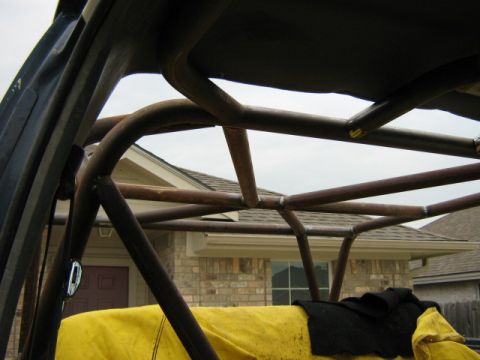 1986 Ford Bronco - Custom roll cage structure is visible inside a vehicle, obscuring most of the exterior.