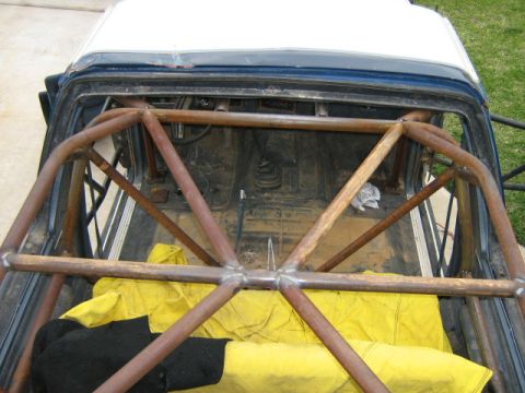 1986 Ford Bronco - Custom roll cage installed in the interior of a vehicle, covering the rear seating and cargo space.