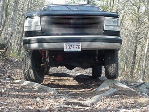 1993 Ford Bronco - Front view of a black Ford truck navigating rocky terrain.