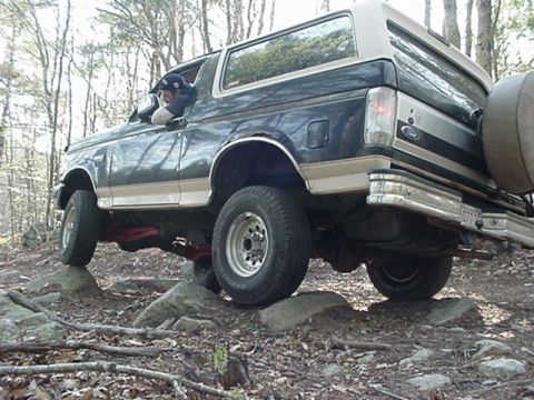 1993 Ford Bronco - This 1993 Ford Bronco navigates rocky terrain in a wooded area.