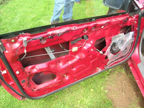1996 Ford Probe - The interior of a red car door is visible, showing its internal components and wiring.
