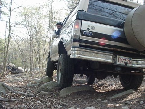 1993 Ford Bronco - This Ford Bronco is navigating a rocky trail, with a person looking out the driver's side window.