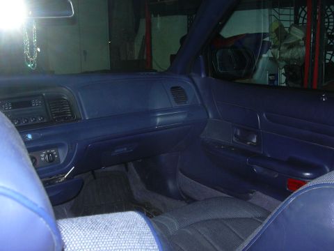 1996 Ford Crown Victoria - Interior view of a blue dashboard and door panel, showing the driver's side of the cabin.
