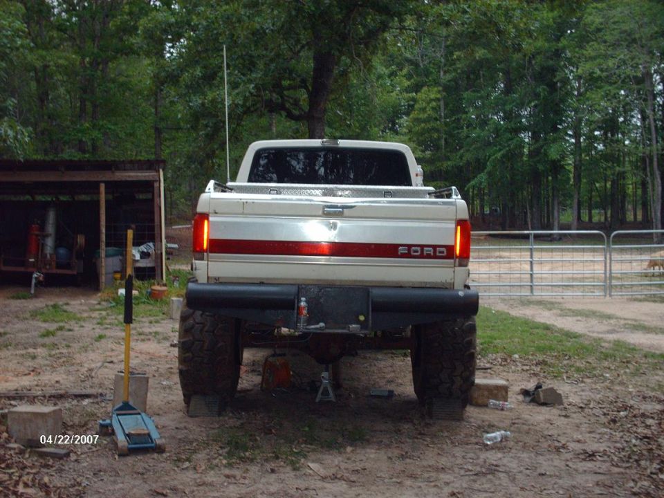 1990 Ford F-150 rear view, lifted with large tires, parked outdoors