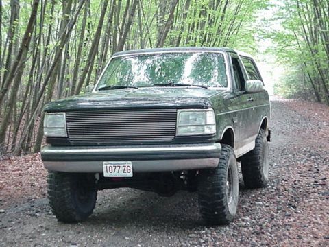 1993 Ford Bronco - This Ford Bronco is seen on a gravel road surrounded by trees.