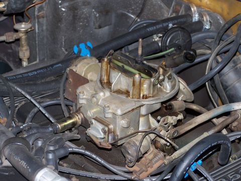 1973 Ford Ranchero - A detailed view of a carburetor and surrounding engine components, highlighting the complexity of the engine bay.