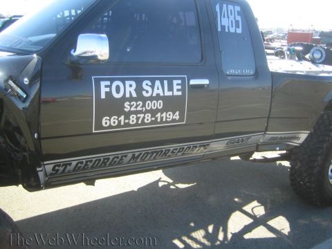 1990 Ford Bronco - Close-up of a black truck's side showing a For Sale sign reading $22,000 and 661-878-1194 with St. George Motorsports rocker graphics.