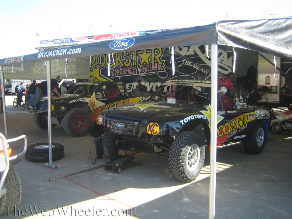 Rockstar Energy off-road race trucks under a pit canopy