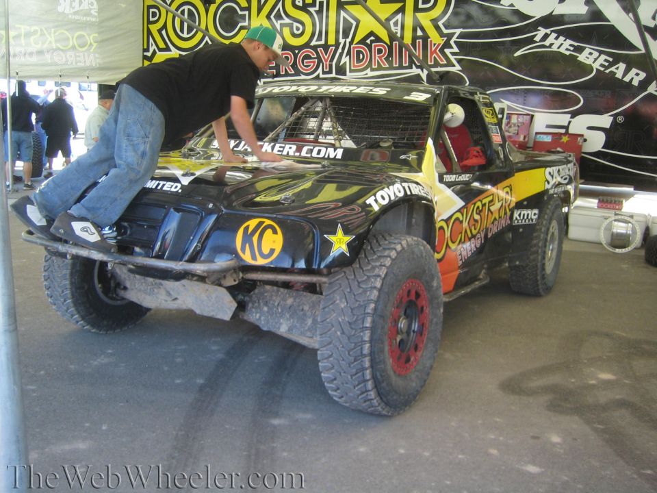 Man leaning over a black Rockstar Energy off-road race truck