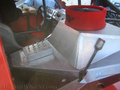 1990 Ford Bronco - interior of an open-cockpit off-road buggy showing a steering wheel, aluminum dash, sequential shifter and a round red air filter.