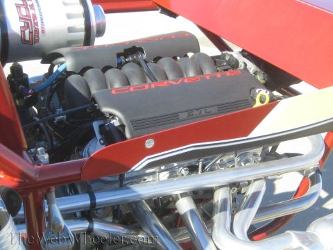 1990 Ford Bronco - Corvette LS engine with red lettering and a cylindrical air filter mounted in the rear of a red tube-frame off-road buggy.