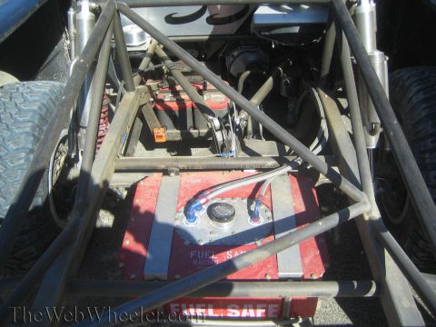 1990 Ford Bronco - Looking into a tube-chassis racer shows plumbing, suspension and a red Fuel Safe racing fuel cell mounted low in the frame.