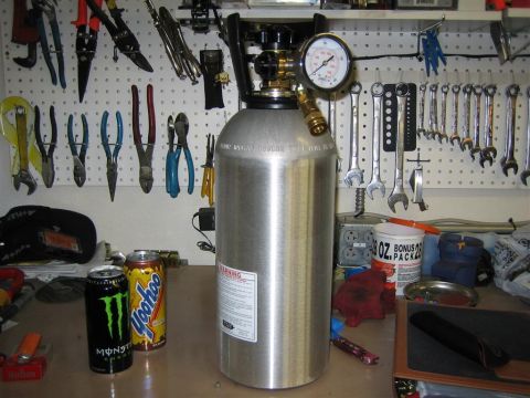 1987 Suzuki Samurai - A brushed-aluminum compressed gas cylinder with a brass valve, regulator gauge reading zero, and quick-disconnect fitting stands on a clutt…