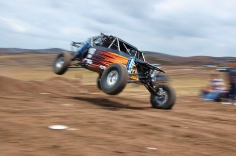 1992 Ford Explorer - Custom off-road buggy airborne during a jump on a dirt track.