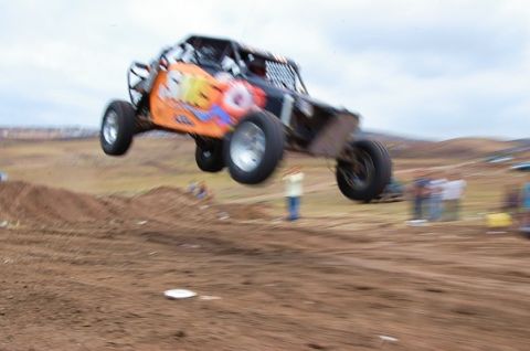 1992 Ford Explorer - This off-road buggy is captured mid-jump against a cloudy sky.