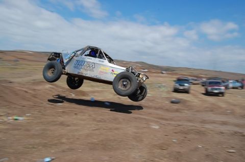 1992 Ford Explorer - An off-road buggy soars through the air during a race, with other vehicles visible in the background.