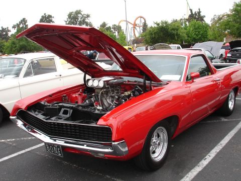 1993 Ford Taurus - A bright red 1970 Ford Ranchero is displayed with its hood open, revealing a powerful engine and custom chrome wheels.