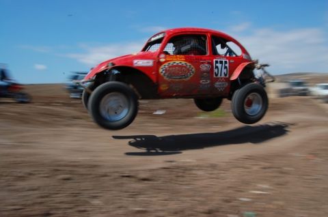 1992 Ford Explorer - Off-road racing Volkswagen Beetle catches air during a competition event.