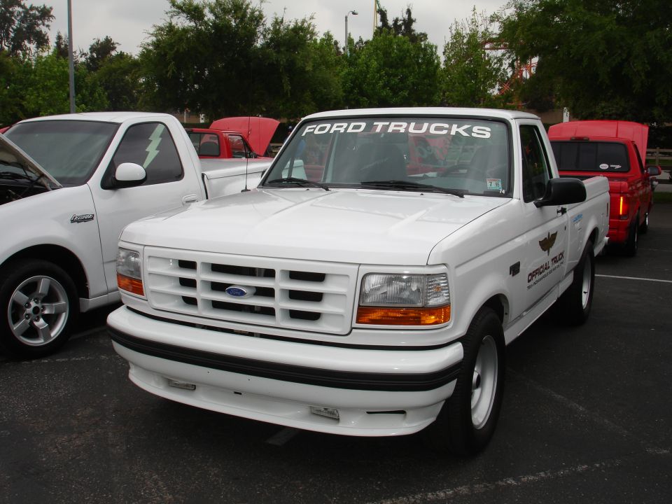 White Ford F-150 pickup truck, front 3/4 view, grille and headlights visible