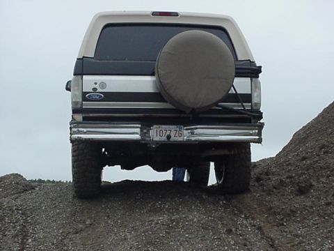 1993 Ford Bronco - Rear view of a 1993 Ford Bronco parked on a dirt mound. The spare tire is mounted externally.