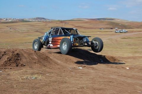 1992 Ford Explorer - Custom off-road buggy airborne during a jump on a dirt track.