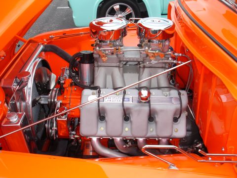 1993 Ford Taurus - Close-up of a custom orange engine bay dual carburetors and "BOSS 429" valve covers, with another vehicle visible in the background.
