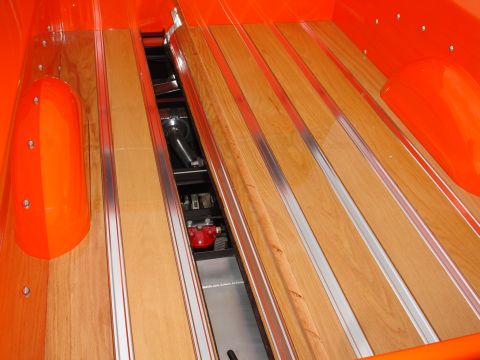 1993 Ford Taurus - Custom wood and aluminum bed in an orange pickup truck, revealing suspension parts below.